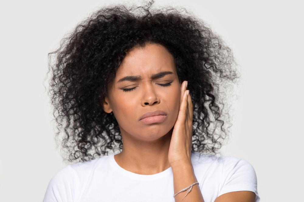woman holding her jaw from a dental emergency