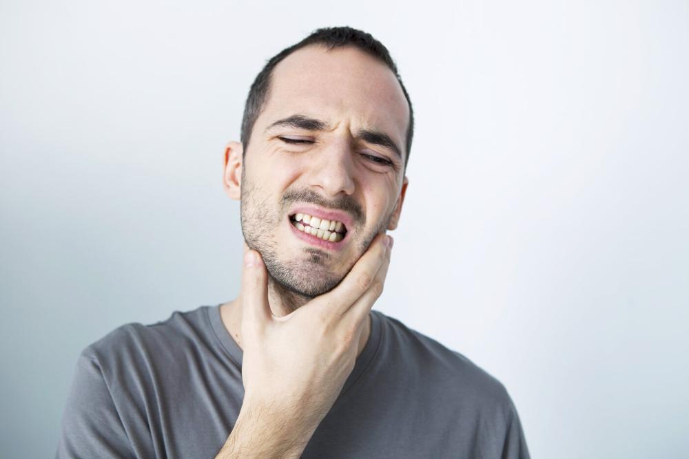 man holding jaw from TMJ pain in Midtown Manhattan