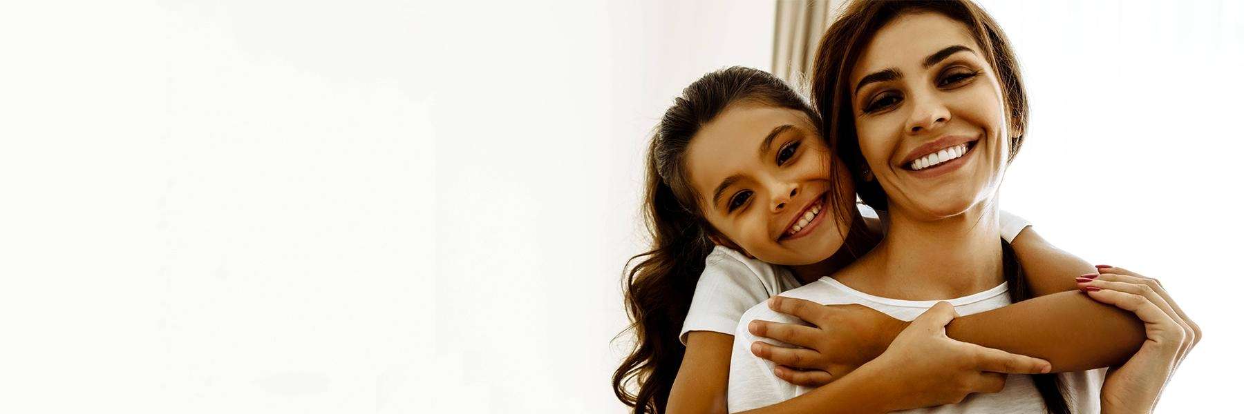 Mother and daughter smiling at dentist in NYC