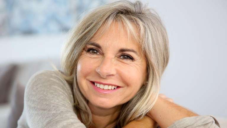woman smiling after cosmetic services