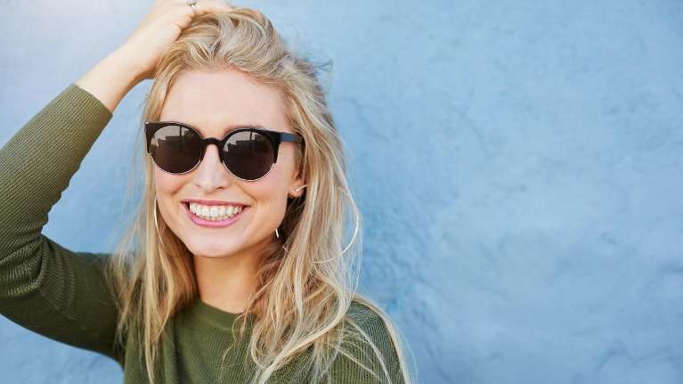 woman smiling with sunglasses on in midtown manhattan